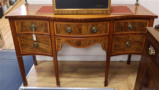 An Edwardian satinwood serpentine fronted mahogany sideboard, with tubular brass railed back W.152cm